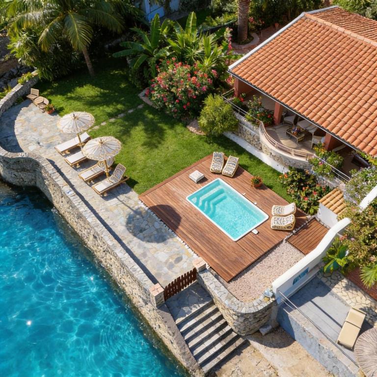 an aerial view of a house with a swimming pool at Yiannis Seafront Villa Paleokastritsa in Paleokastritsa
