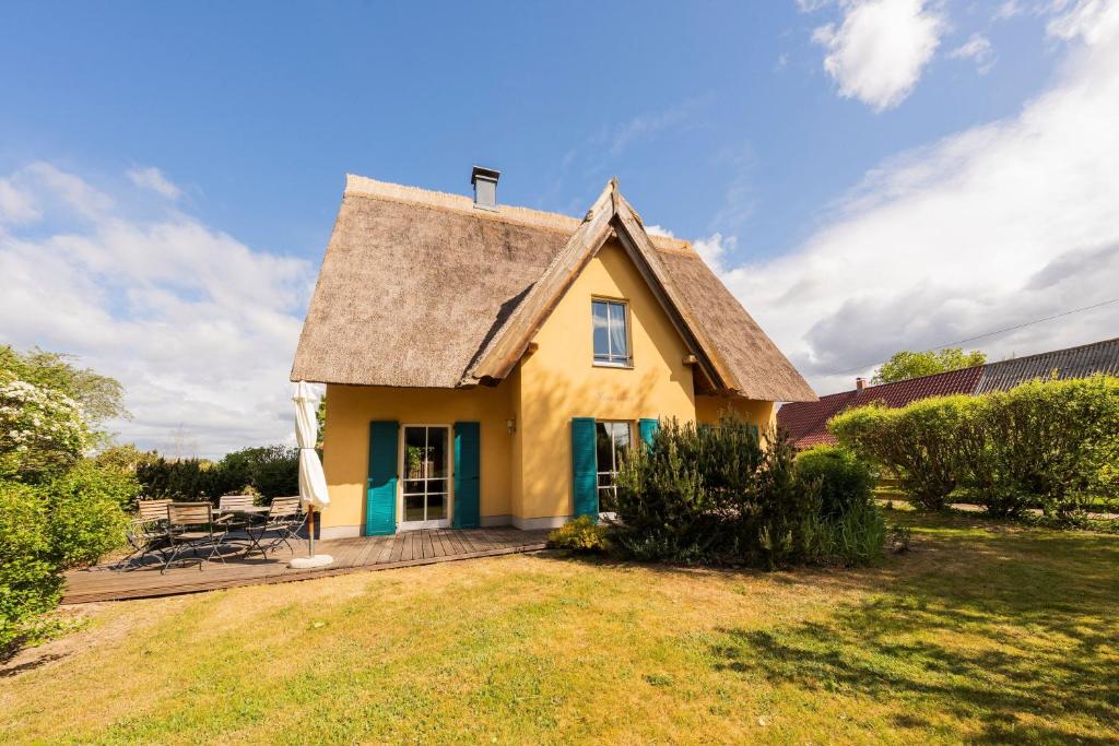 a small yellow house with a thatched roof at Ferienhaus Möwe in Krienke