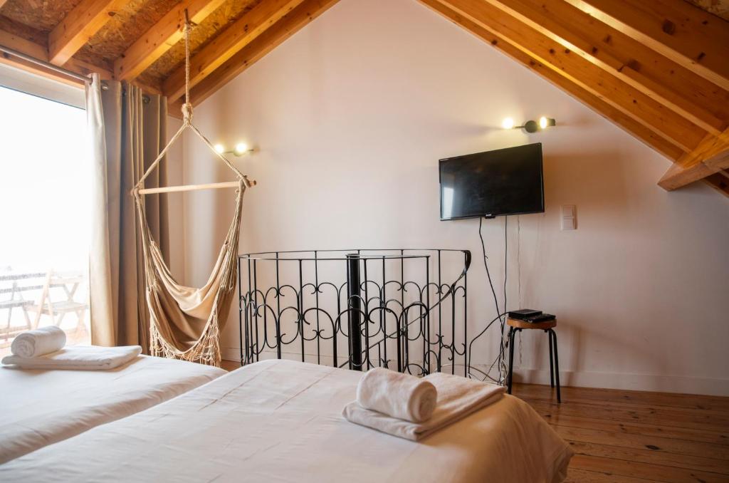 a bedroom with two beds and a flat screen tv at Villa 2 Quartos by WOT Lodge Soul in Ericeira