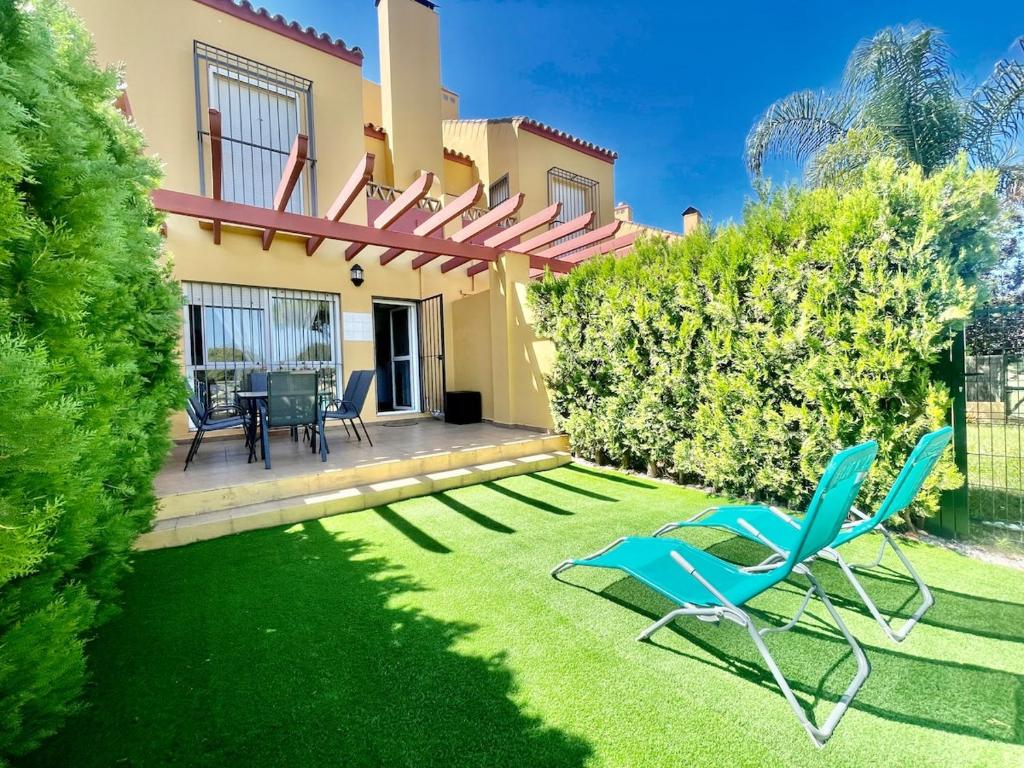 a yard with two chairs and a house at Albatros Golf 2 - Islantilla in Isla Cristina