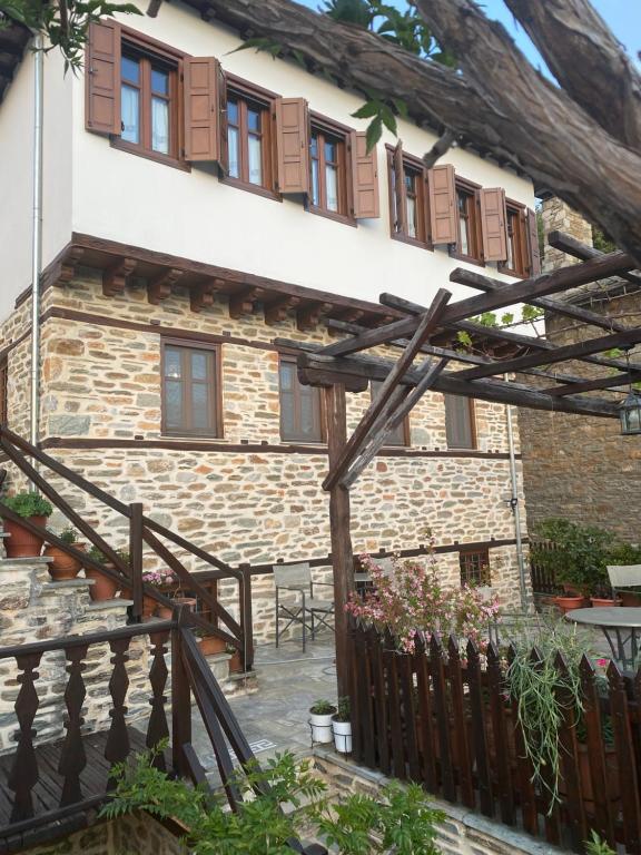 a house with a wooden fence and a patio at Αρχοντικό Μελλιώ Άγιος Λαυρέντιος in Agios Lavrentios