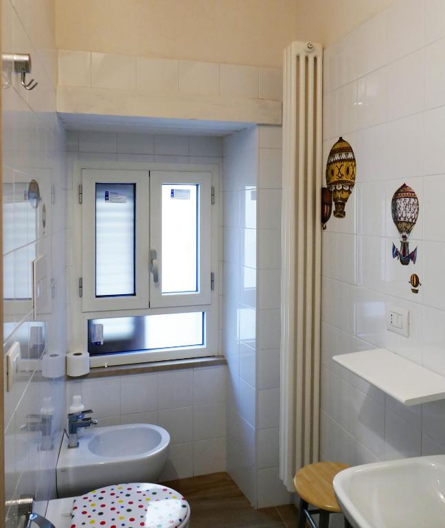 biała łazienka z umywalką i oknem w obiekcie B&B Il Campanile w mieście Barletta