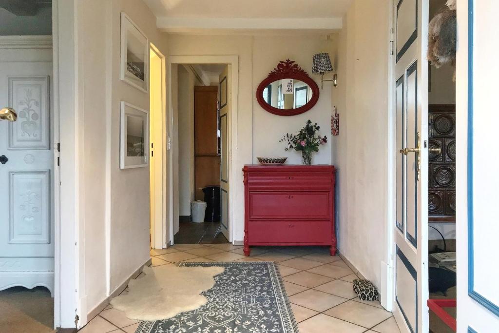 a red dresser in a hallway with a red mirror at Midlum- Finnegan, EG in Midlum