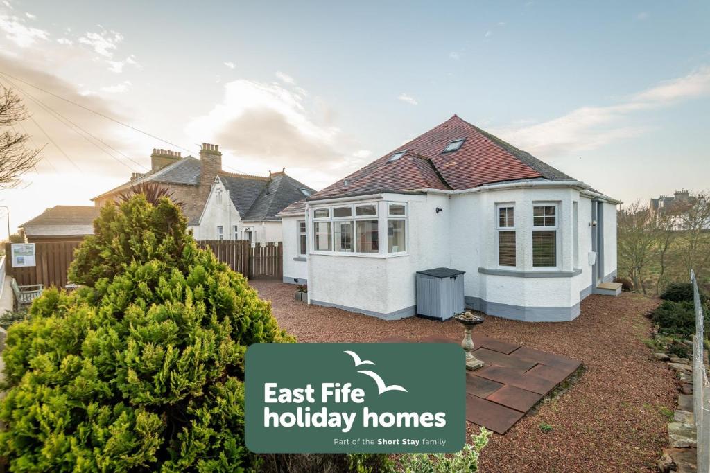 a house with a sign that says east fire holiday homes at Avoncliffe in Crail