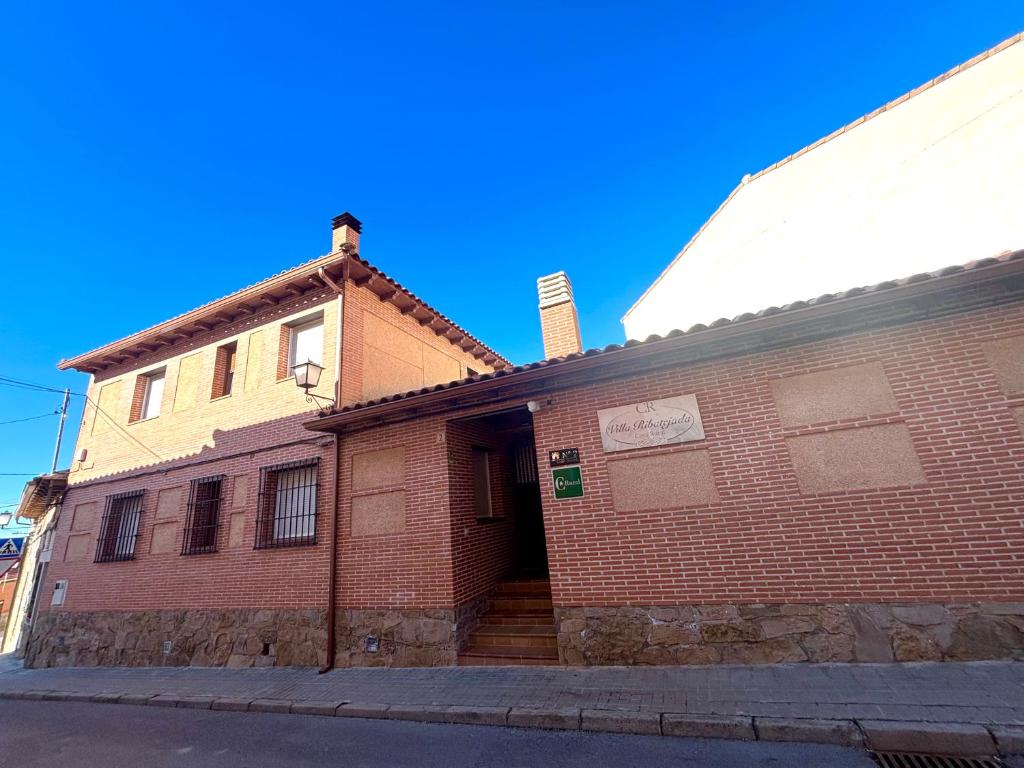 an old brick building on the side of a street at Casa Rural Villa Ribatejada in Ribatejada