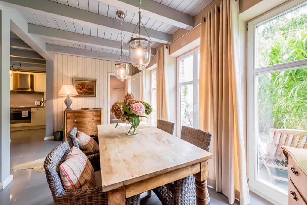 a dining room with a wooden table and chairs at Bauernkate Seerose in Liepe