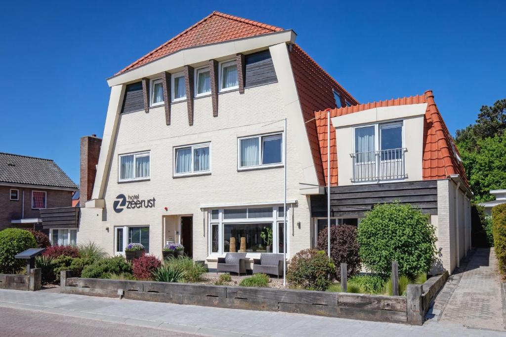 a white house with an orange roof at Hotel Zeerust in De Koog