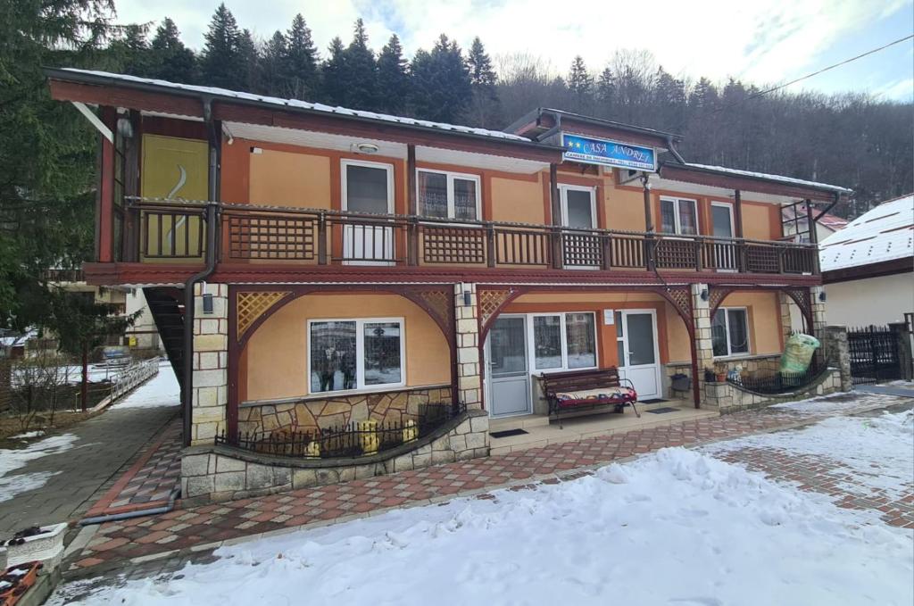 a large building with a balcony in the snow at Casa Andrei in Slănic-Moldova