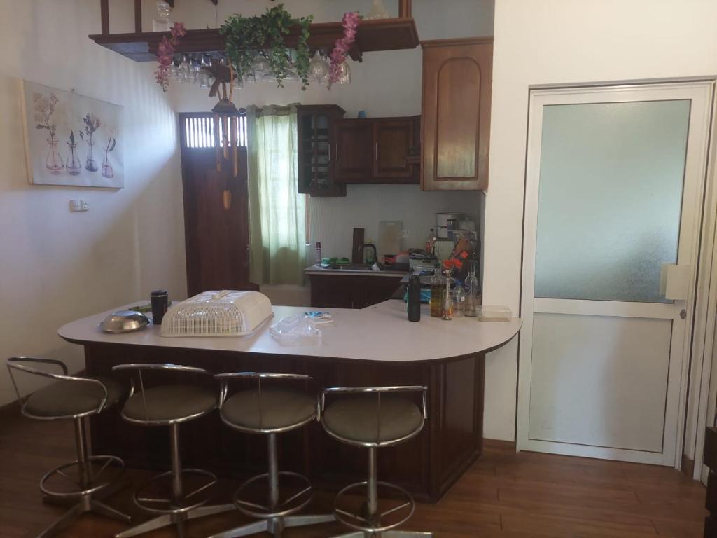 a kitchen with a island with bar stools in it at Sun Power Villa in Hokandara South