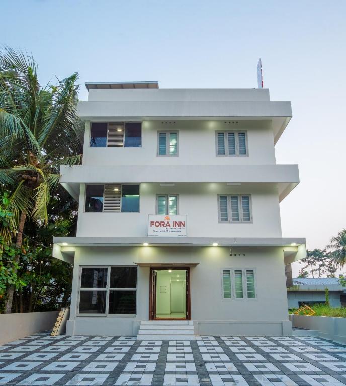 a white building with a sign that reads roof amani at FORA Inn in Cochin