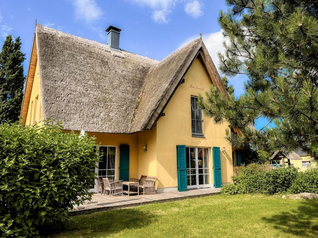 a yellow house with a thatched roof at Ferienhaus Kranich in Krienke