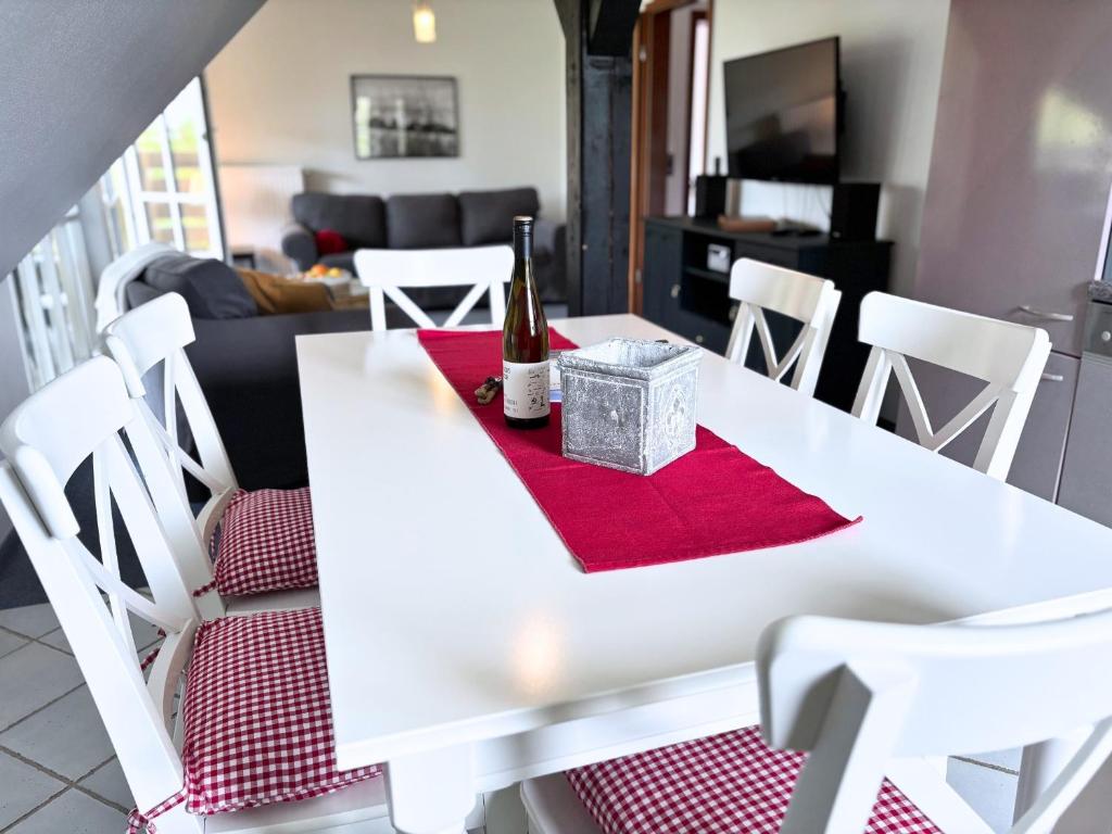 a white dining room table with a bottle of wine on it at Frederick Brückenblick in Wulfen auf Fehmarn