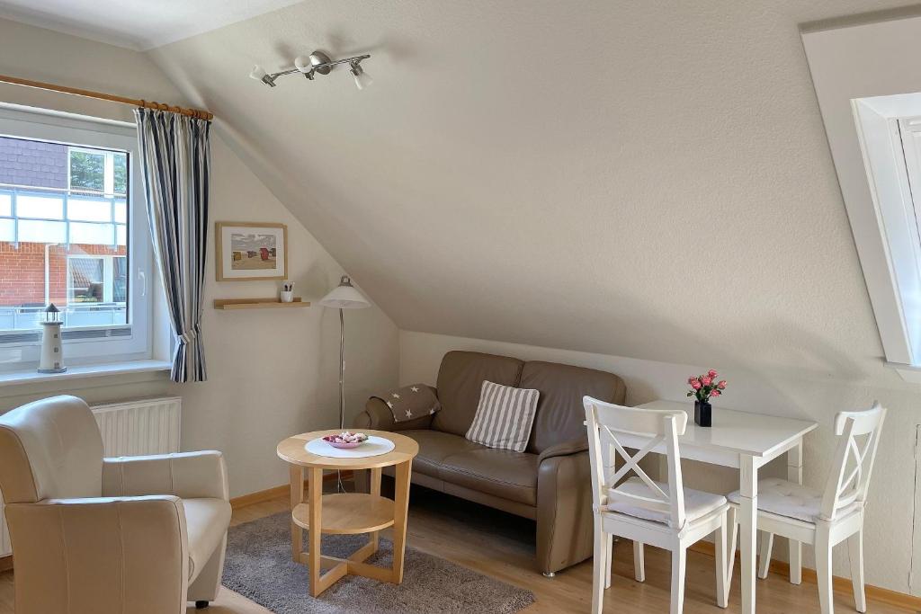 a living room with a couch and a table and chairs at MS Störtebecker, Sandwall in Wyk auf Föhr