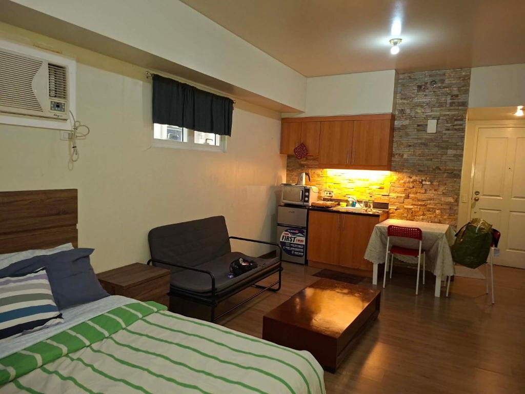 a bedroom with a bed and a kitchen with a table at Celadon Tower- Studio with balcony near SM San Lazaro in Manila