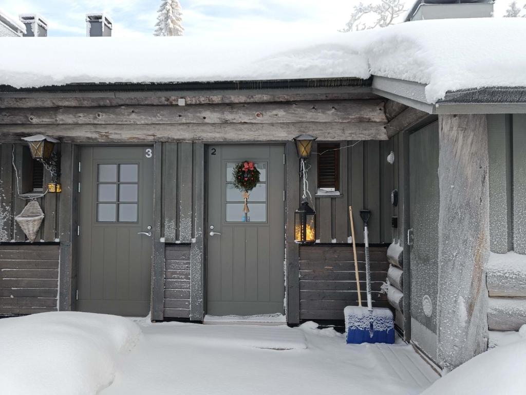 a house with a door covered in snow at TunturinTähti in Syöte