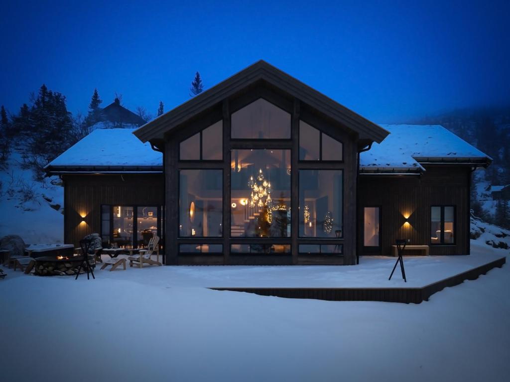 a house in the snow at night at FJELLRO Private Alpine Lodge Høgevarde in Flå