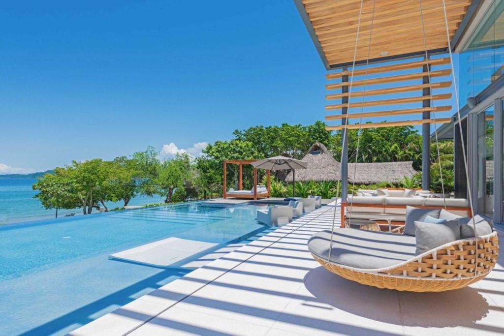 a villa with a swimming pool with a hammock and a resort at Villa Brisa in Punta Mita in Punta Mita