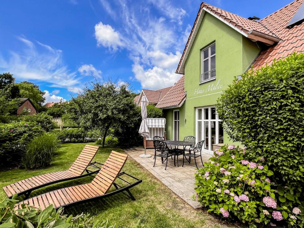 a green house with two chairs and a table at Ferienhaus Malve in Liepe