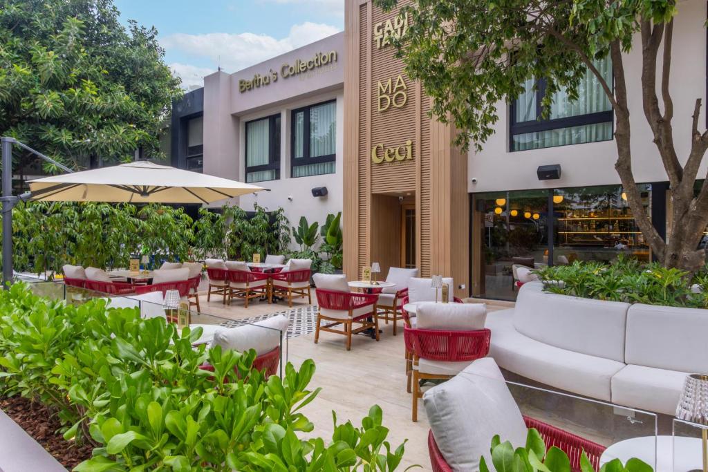 a patio with tables and chairs in front of a building at Berthas Collection By EM Hotels in Cartagena de Indias