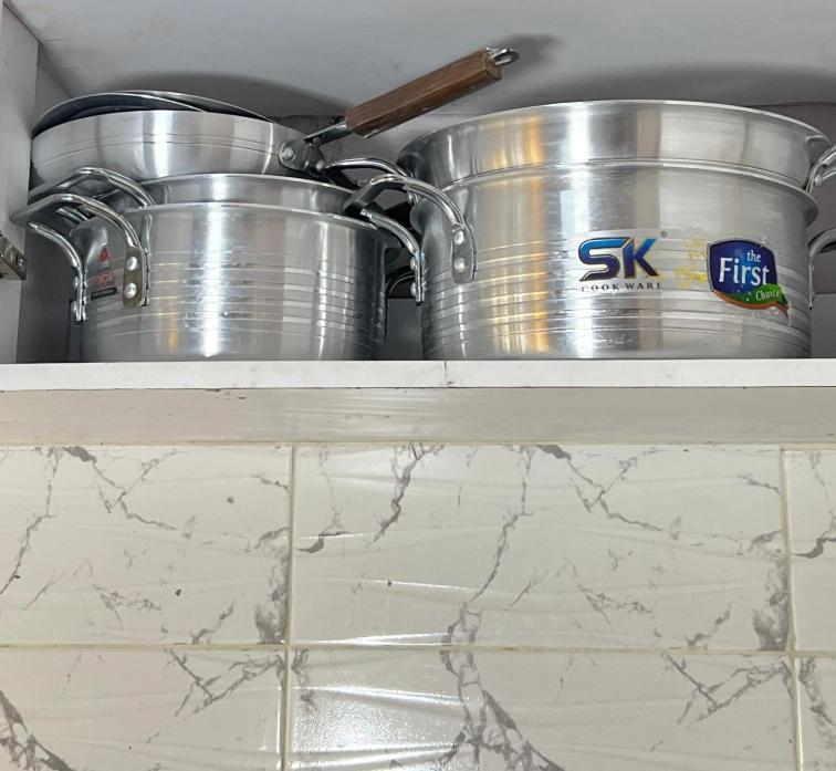 two pots and pans sitting on a shelf in a kitchen at Manja Homes in Ruiru