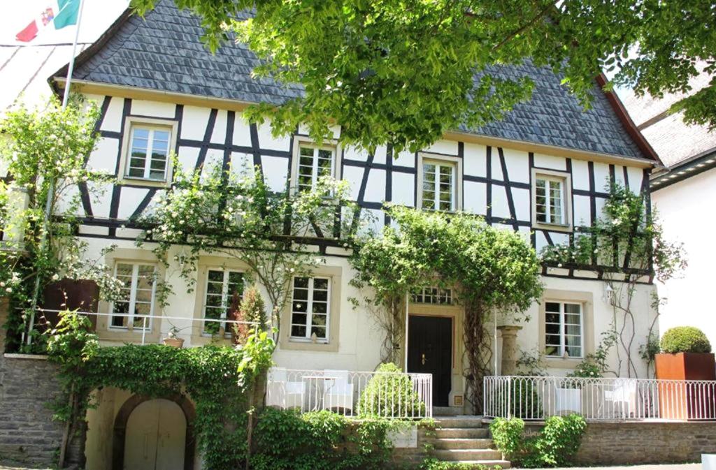 a house with a black and white building at Mosel-Side De Luxe Suite in Reil