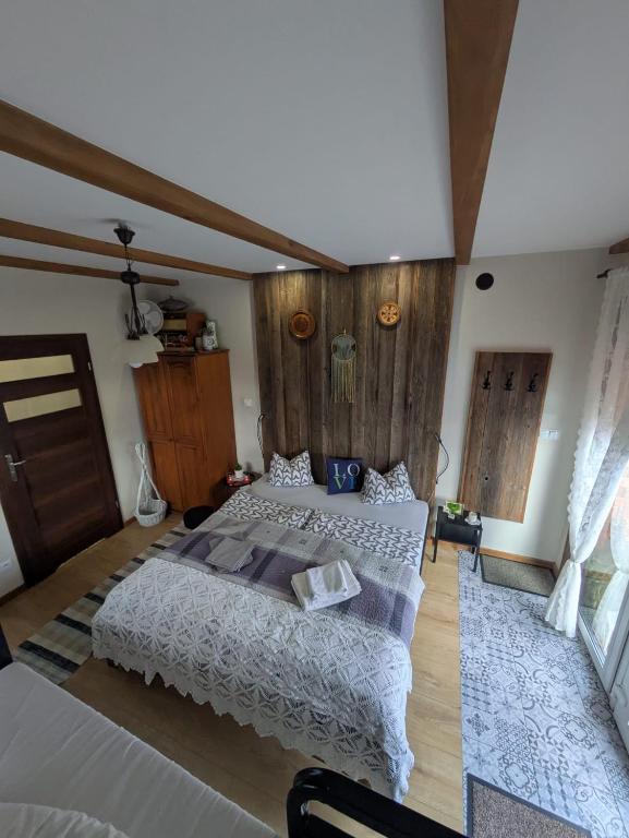a bedroom with two beds and wooden walls at Agroturystyka DANA in Debrzno