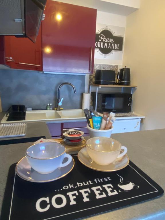 a kitchen counter with two bowls and a coffee sign at Aéroport à pied, Escale 25 in Tillé