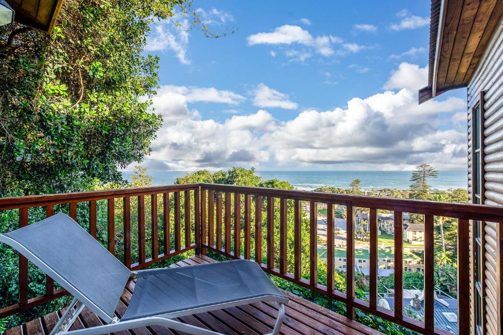 a deck with a chair and a view of the ocean at 7 On Boardwalk in Wilderness