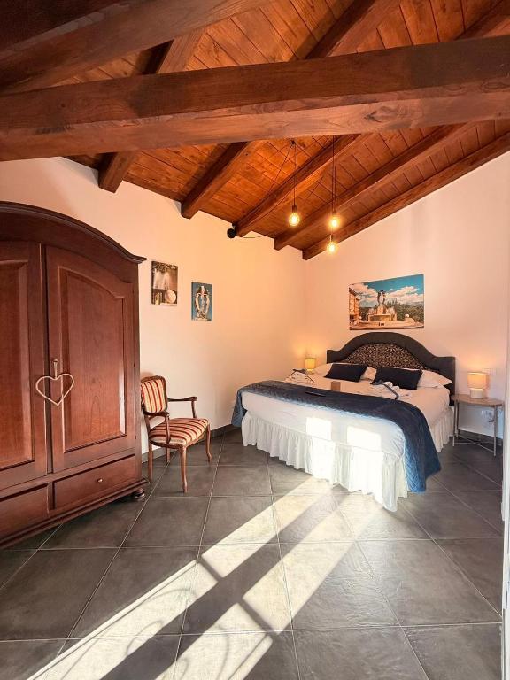 a bedroom with a bed and a chair in a room at MECE Rooms in LʼAquila