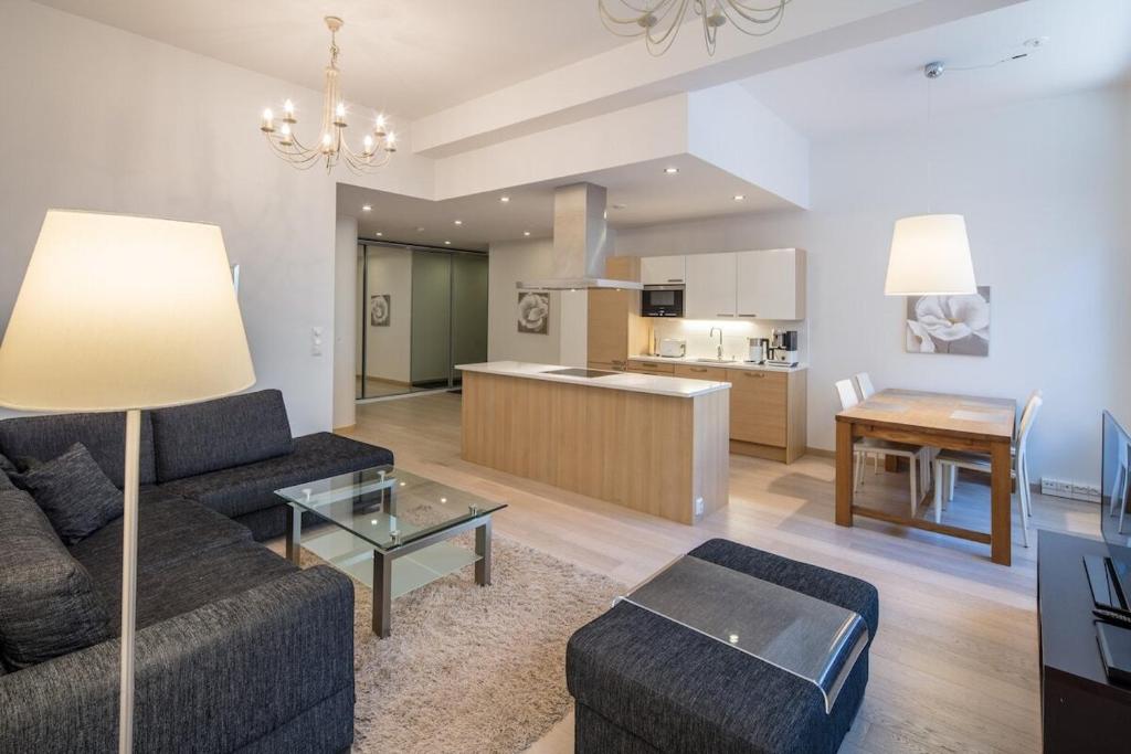 a living room with a couch and a table and a kitchen at Gella Munkkisaarenkatu 2 in Helsinki