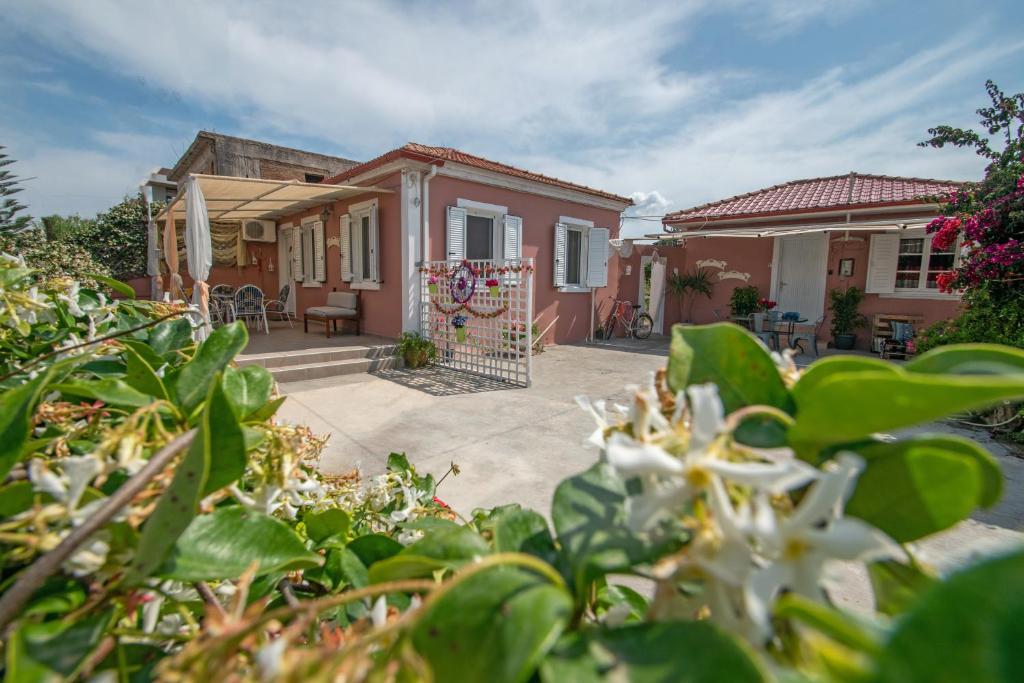 a house with a gate in front of a yard at Dora's Beach Cottages in Planos