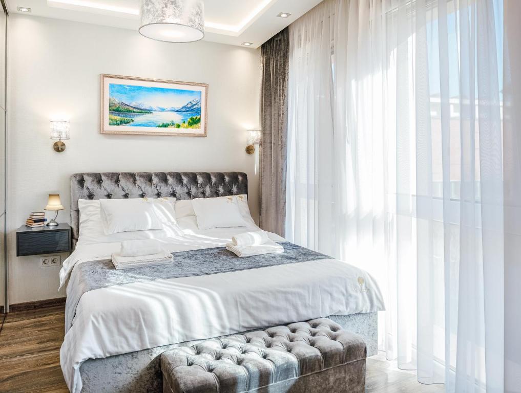 a bedroom with a bed and a large window at Rebany Apartman 2 Free parking, Central Location in Debrecen