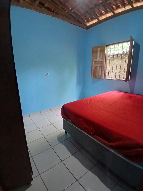 a bedroom with a red bed and a window at Férias da Hora in Prado