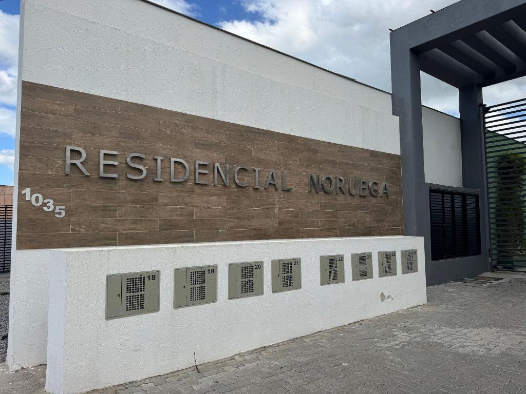 a building with a sign that reads residential mortgage at Condomínio Noruega - casas 2 dormitórios in Jaguarão