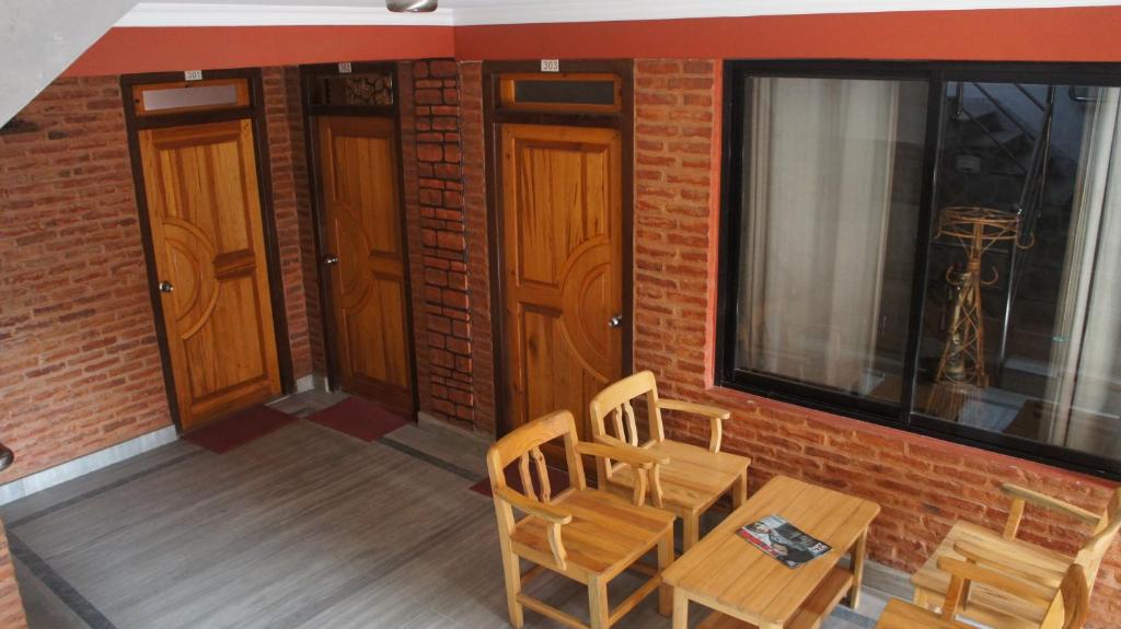 balcón con 2 sillas, mesa y 2 puertas en City Guest House, en Bhaktapur