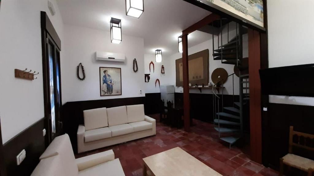 a living room with a white couch and a table at APARTAMENTO La CAVA in Guadalcanal