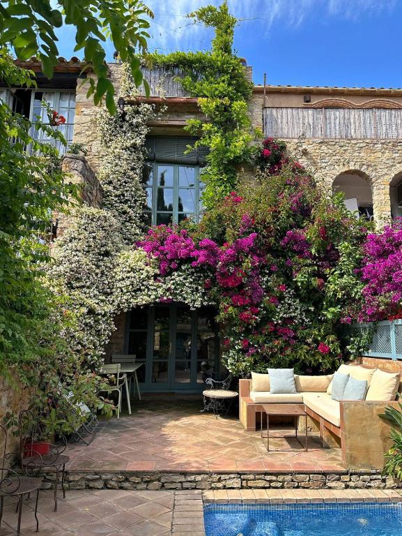 a house with flowers on the side of it at ¡Vistas al Castillo Casa con Piscina en el Centro in Peratallada