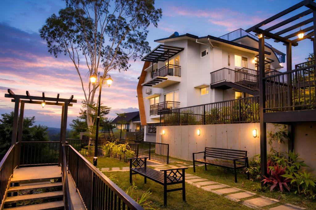 a building with benches in front of it at dusk at Ymoon Mountain Resort Wayanad in Koroth