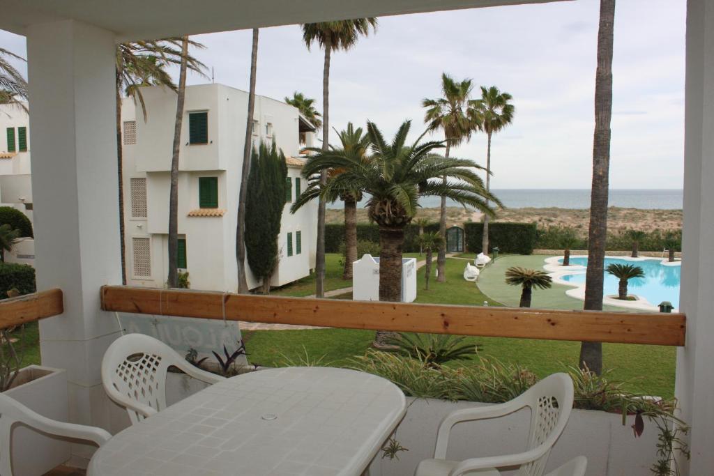 a balcony with a table and a view of a pool at Deltamar Solo Familias Serviplaya in Xeraco