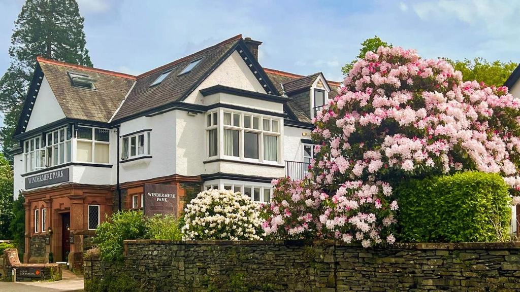 a large house with pink flowers in front of it at Windermere Park B&B inc Free off-site Health Club in Windermere