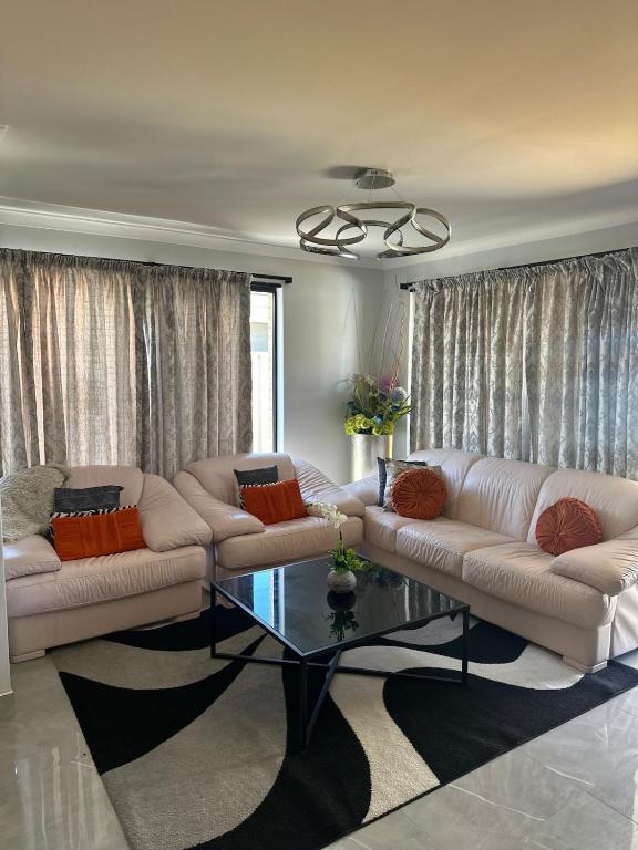 a living room with two couches and a glass table at Slate House Caversham in Caversham