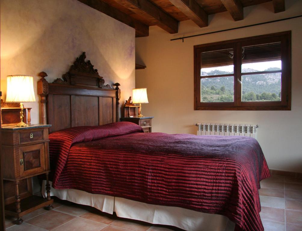 a bedroom with a large bed and a window at Casa Morató in Beceite