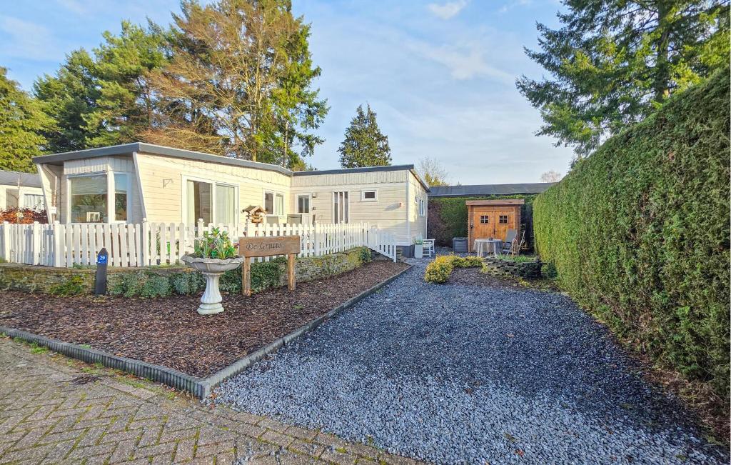 a home with a white fence and a house at Nice Chalet In Putten in Putten
