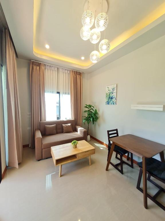 a living room with a couch and a table at Samati Hill - Pool Villa H2- Klong Ning Beach in Ko Lanta Yai