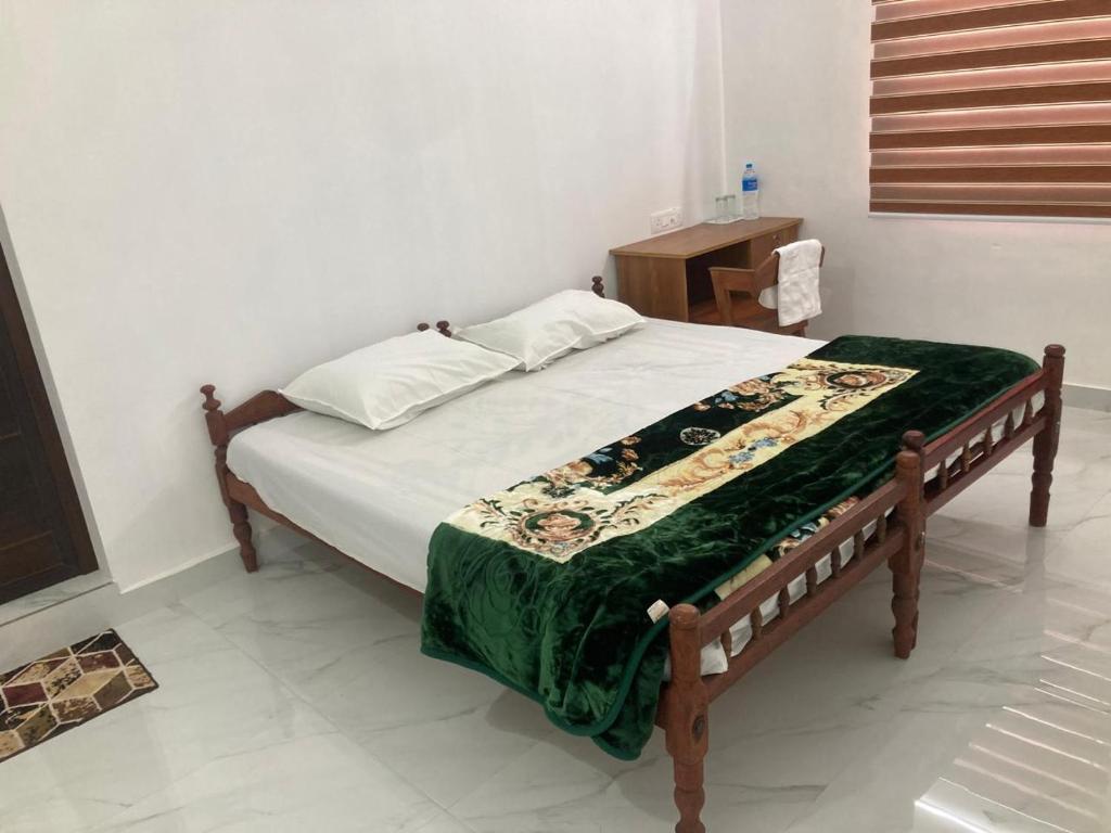 a bedroom with a bed with a green blanket at Valiyaveettile in Alwaye