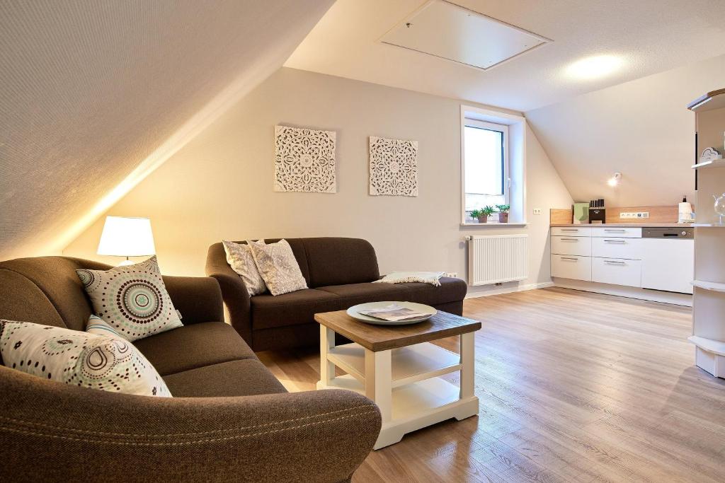 a living room with two couches and a table at Südstern OG, Schwalbenweg in Wyk auf Föhr