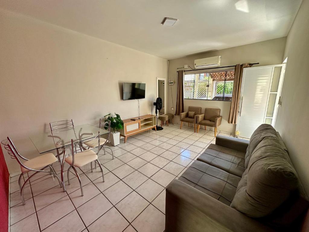 a living room with a couch and a table and chairs at Casa no Centro in Corumbá