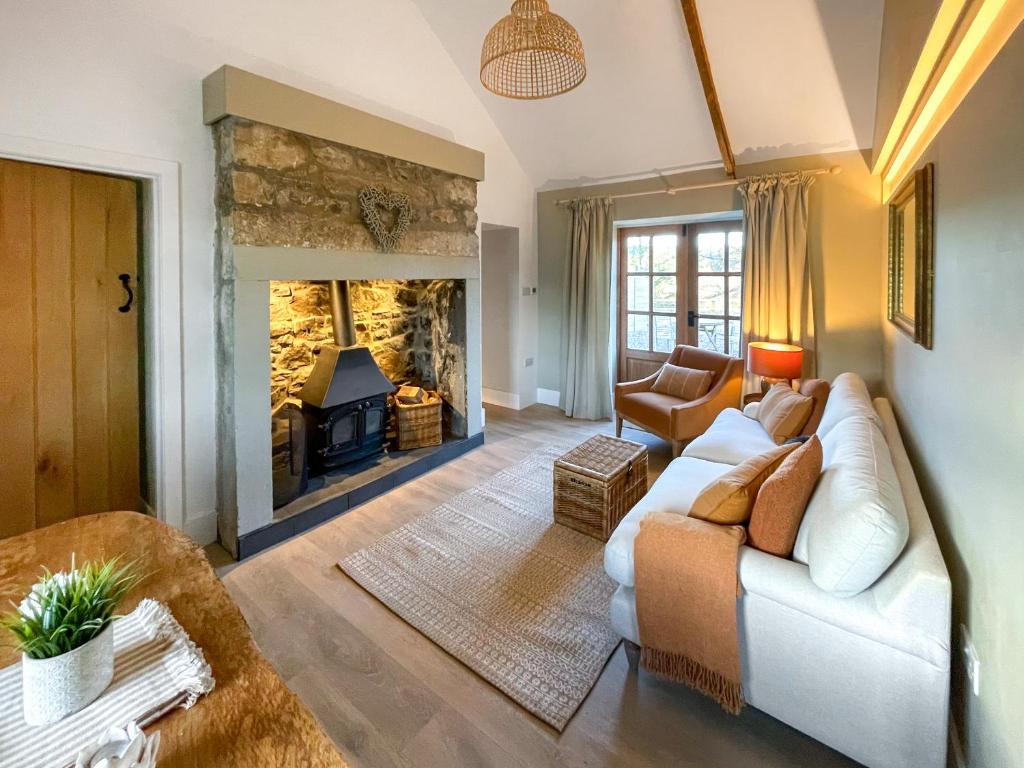 a living room with a couch and a fireplace at Night Sky Cottage in Kielder