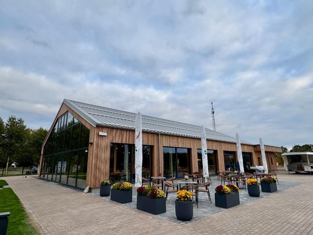 a building with tables and chairs in front of it at Caravanserei Resort Oberhavel in Oranienburg