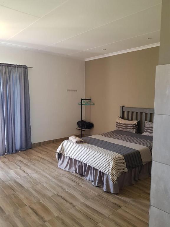 two beds in a room with wooden floors at Bredell Motel in Bredell